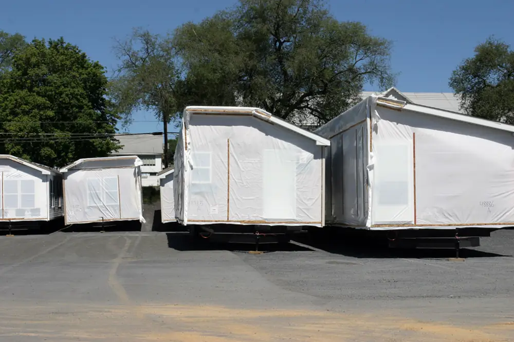 Manufactured home sections wrapped and waiting to be hauled